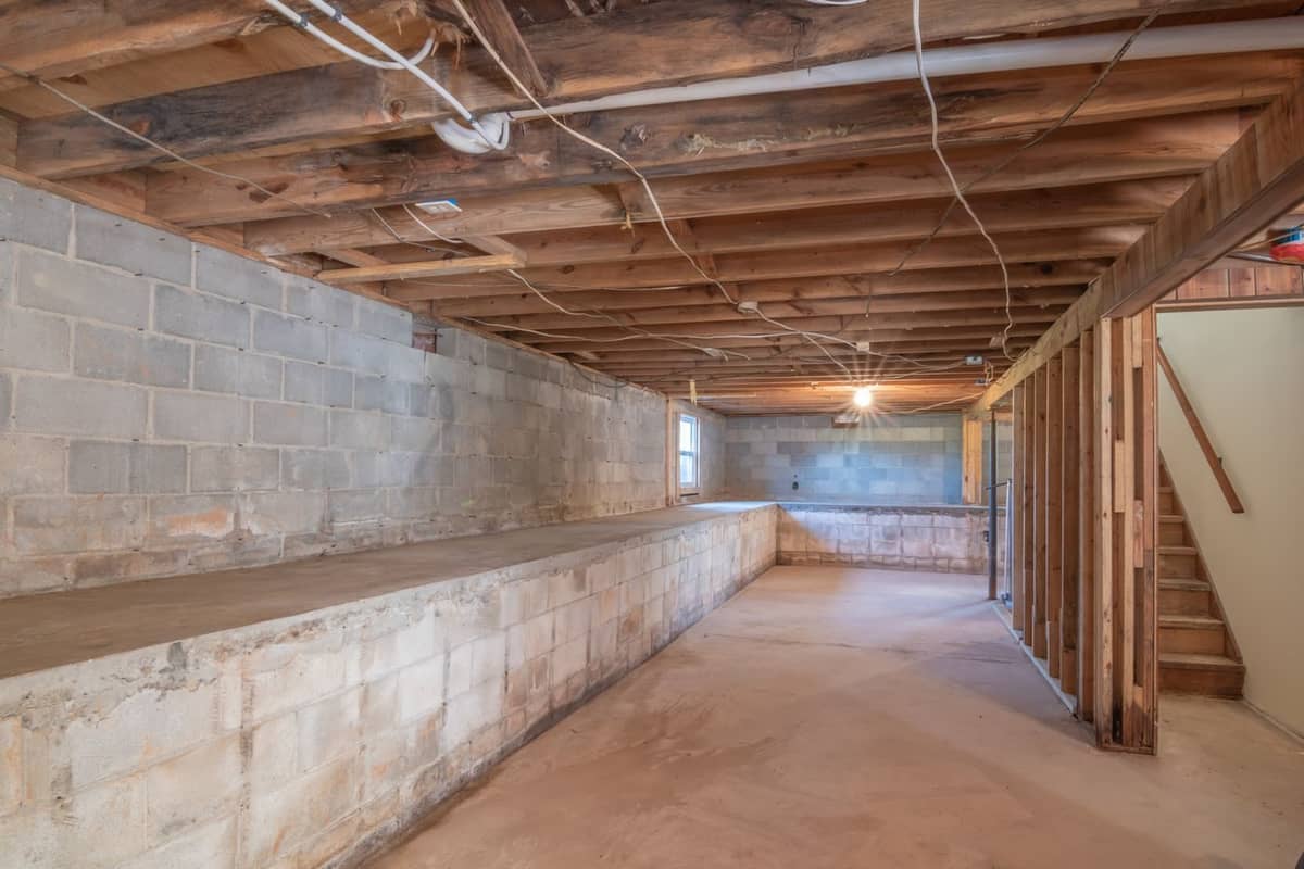 Unfinished basement with exposed floor joists resting on the foundation walls