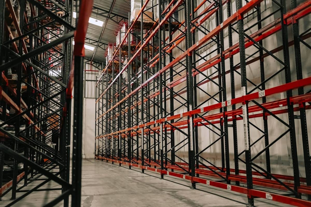 Warehouse interior with tall steel pallet racks and a high ceiling